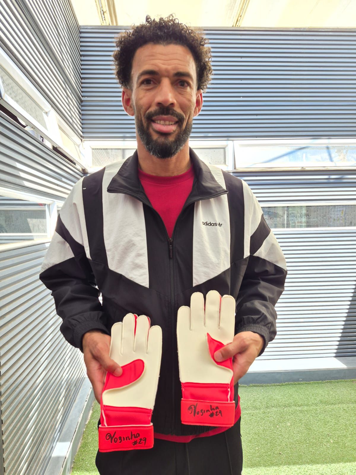Vozinha con los guantes de fútbol autografiados
